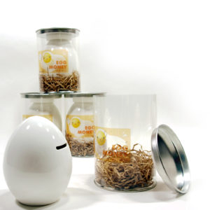 egg shaped coin bank shown with container