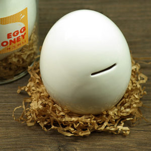 egg shaped coin bank on straw bed with container